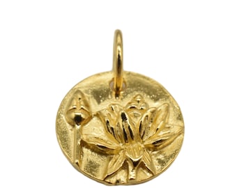 May include: A gold-colored pendant featuring a detailed lotus flower design. The pendant has a circular shape with a loop at the top for a chain. The lotus flower is in full bloom, with a bud to the left.