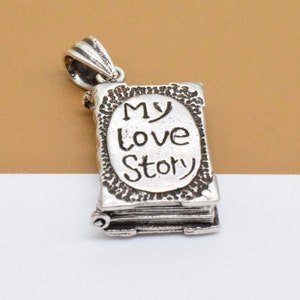 May include: Silver charm in the shape of a book with the words "My Love Story" engraved on the front.