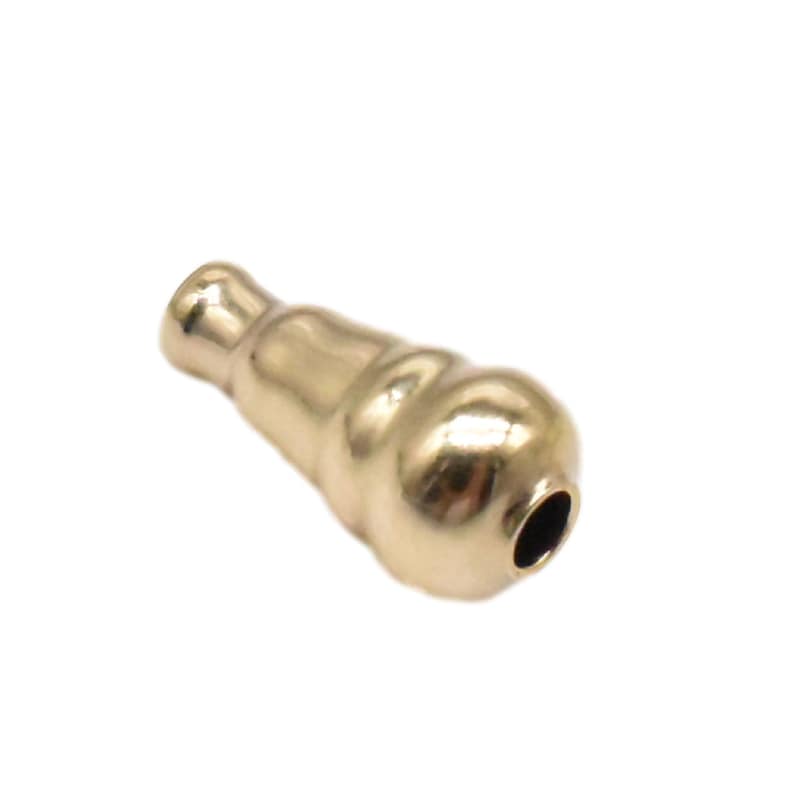 May include: A gold-colored metal pendant in the shape of a teardrop with a round opening at the bottom.