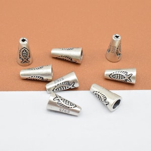 May include: Seven silver cone-shaped end caps with a fish design and the inscription "S925" on each.