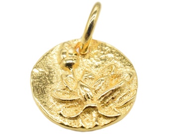 May include: A gold-toned pendant featuring a lotus flower design. The pendant is round and has a textured surface.