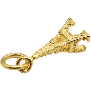 May include: Gold-toned Eiffel Tower charm with a loop for attaching to a necklace or bracelet.