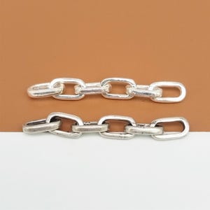 以下が含まれることがあります： 2本の銀色のチェーン。1本は滑らかな仕上げ、もう1本はテクスチャ加工が施されています。両方のチェーンは楕円形のリンクでできています。