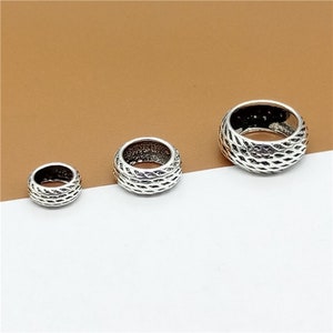 May include: Three silver rings with a textured design. The rings are different sizes and are arranged in a row from largest to smallest.