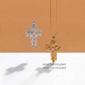 May include: A silver-toned cross pendant and a gold-toned cross pendant on a chain, both featuring intricate filigree metalwork and small pink spherical beads inside. The text "pearl not included" and "chain not included" is visible.