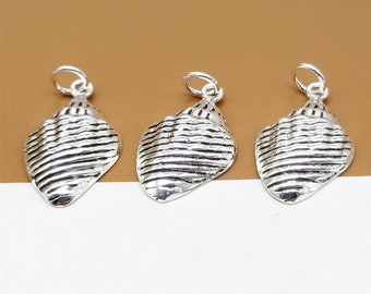 Könnte beinhalten: Drei silberne Muschel-Anhänger mit strukturiertem, gestreiftem Design. Die Anhänger haben eine Öse oben zum Anbringen an Schmuck.