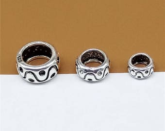 May include: Three silver rings with a wavy pattern. The rings are different sizes.