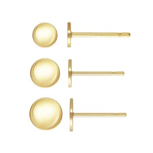 May include: Three pairs of gold stud earrings with round, smooth tops. The earrings are different sizes.