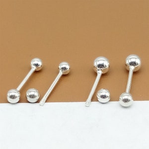 May include: Three pairs of silver ball stud earrings. Each earring has a small, round ball on each end of a straight post.