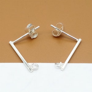May include: A pair of silver earring findings with a straight bar and a jump ring. The findings are designed to be used with other jewelry components.