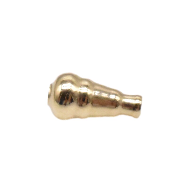 May include: A gold-colored metal bead with a rounded, bulbous shape and a slightly tapered end.
