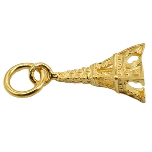May include: Gold-toned Eiffel Tower charm with a loop for attaching to a necklace or bracelet.