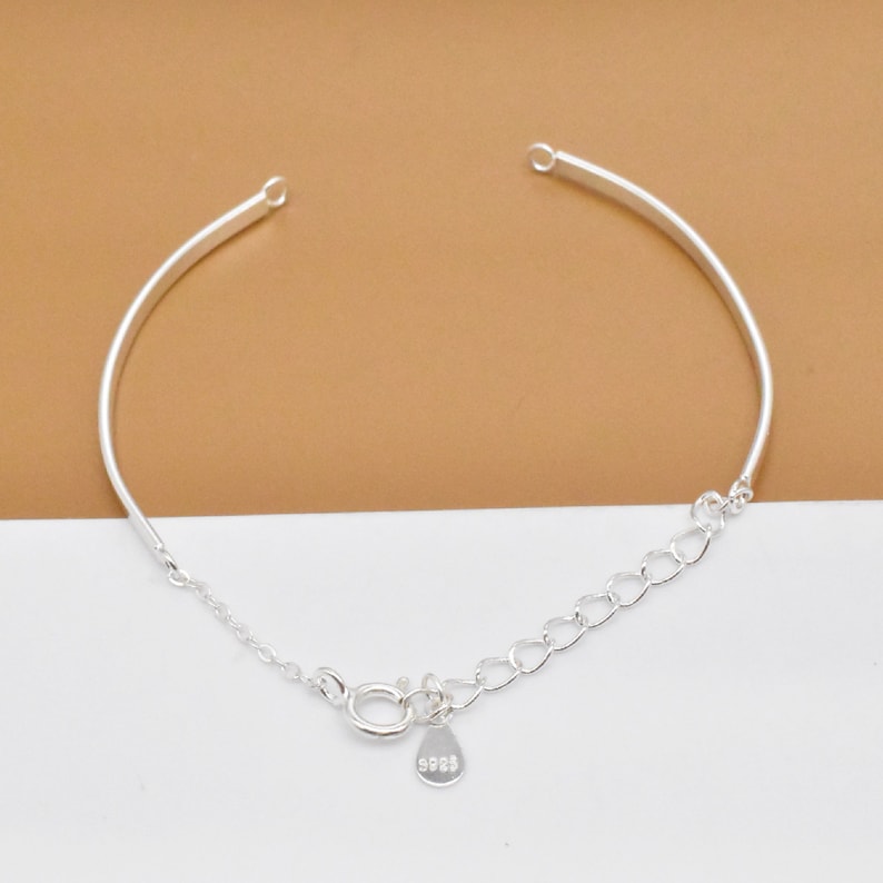 May include: A silver bracelet with a delicate chain and a small tag that says "925".