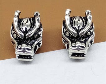 May include: Two silver dragon head beads with detailed carvings. The beads are a traditional Chinese design and are perfect for jewelry making or adding a unique touch to any project.