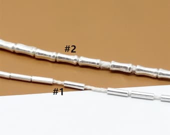 Puede incluir: Dos cadenas de plata con eslabones de diferentes tamaños. La cadena superior está etiquetada como #2 y la cadena inferior como #1.
