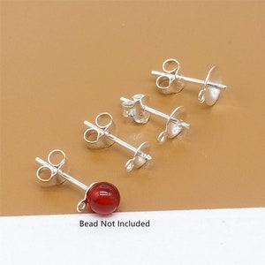 May include: Four silver earring posts with a red bead on one of the posts. The text "Bead Not Included" is below the image.