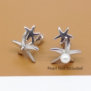 Op de afbeelding: Een paar zilveren zeester-oorbellen met een parel in het midden van elke zeester. De tekst "Pearl Not Included" is onder de oorbellen gedrukt.
