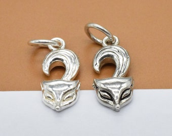 May include: Two silver fox head charms with a loop for attaching to a necklace or bracelet. The fox heads are detailed with a curled tail and a face with eyes and a nose.