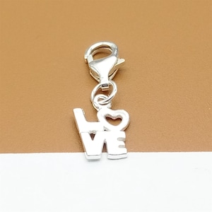 Dije de plata de ley con forma de palabra de amor, letra de amor en plata 925, cierre de mosquetón para pulsera y collar.