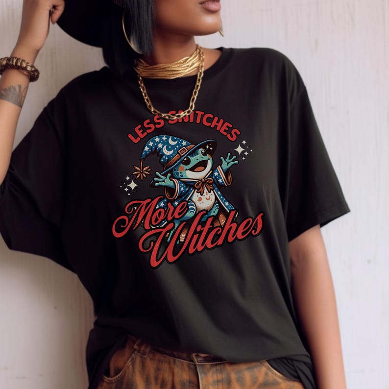 May include: Black t-shirt with a cartoon frog wearing a wizard hat and the text "Less Snitches More Witches".