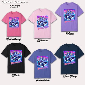 May include: A collection of Comfort Colors t-shirts in various colors, including Crunchberry, Blossom, Violet, Black, Periwinkle, and True Navy. Each shirt features a graphic of orcas and a ship with the text "Eat the Rich".