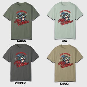 May include: Four t-shirts in different colors, each featuring a cartoon illustration of a frog wearing a wizard hat and holding a wand. The text on the shirts reads "Less Snitchers More Witches". The colors of the shirts are moss, bay, pepper, and khaki.