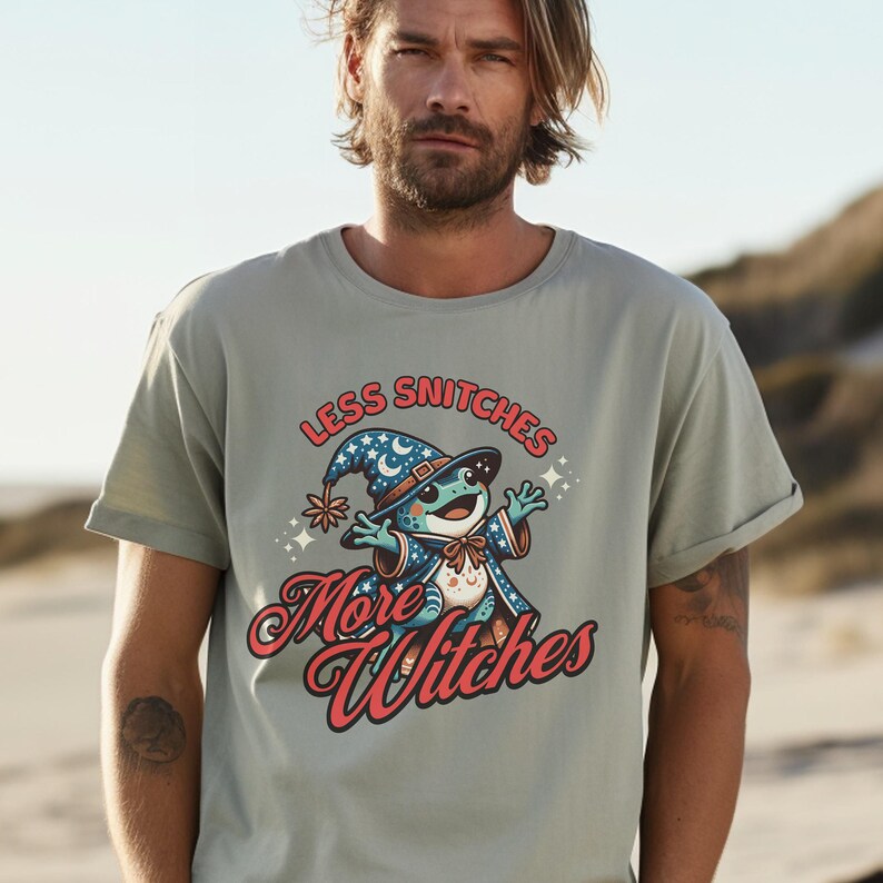 May include: A light green t-shirt with a cartoon frog wearing a wizard hat and robe. The text on the shirt reads "Less Snitchers More Witches".