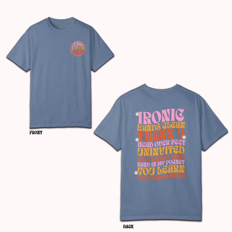 May include: A light blue t-shirt with a graphic on the front that says "I'm not but I'm bottom". The back of the shirt has a graphic with the text "IRONIC HANDS CLEAN THANK U HEAD OVER FEET UNINVITED BUT I'M NOT REALLY HAND IN MY POCKET YOU LEARN WHY I'M LIKE THIS"