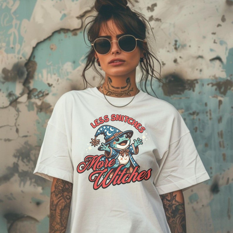 May include: White t-shirt with a cartoon frog wearing a wizard hat and the text "Less Snitchers More Witches".