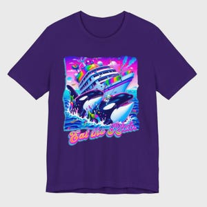 May include: Purple t-shirt with a graphic of two orcas jumping out of the water and attacking a large, rainbow-colored cruise ship. The text "Eat the Rich." is printed below the orcas.