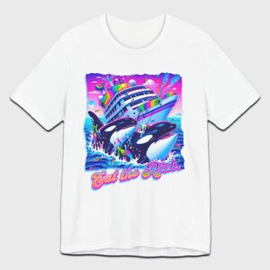 May include: White t-shirt with a graphic print of two killer whales jumping out of the water and attacking a large cruise ship. The graphic is in a rainbow color scheme and the text "Eat the Rich" is printed below the whales.