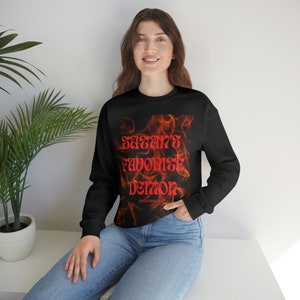 May include: Black sweatshirt with a red graphic print of flames and the text "Satan's Favorite Demon".