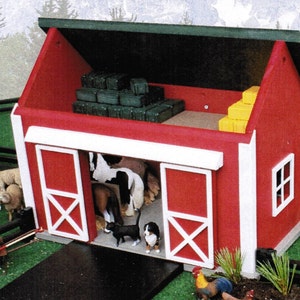 May include: A red wooden barn with a green roof and white trim. The barn doors are open and there are toy farm animals inside, including horses, a cat, and a dog. There are also bales of hay inside the barn.