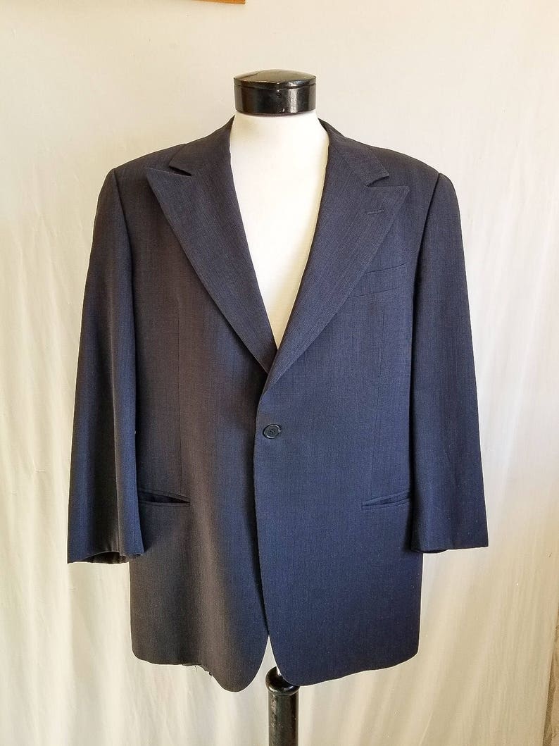 May include: A dark blue blazer with a single button closure and a classic notched lapel.