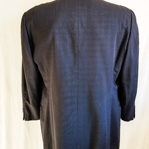 May include: A dark gray blazer with a single back vent. The blazer has a classic, tailored fit.