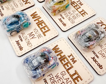 May include: A set of six wooden Valentine's Day cards with toy cars attached. Each card has a different message, including "Wheel You Be My Valentine?" and "I'm Wheelie Glad We're Friends!"