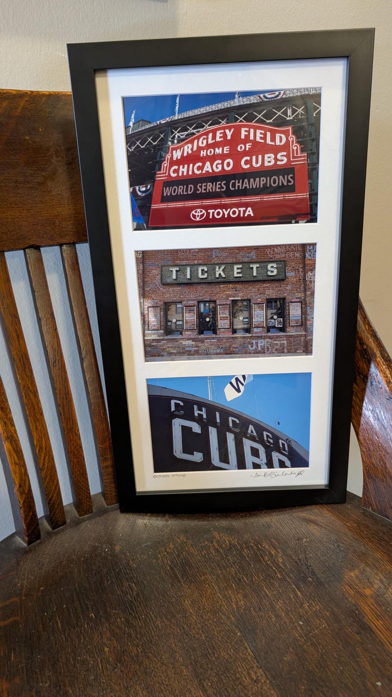 May include: Framed print featuring three images of Wrigley Field, home of the Chicago Cubs. The top image shows the stadium's sign with "World Series Champions" and "Toyota." The middle image displays a brick building with "TICKETS." The bottom image shows the team's logo.