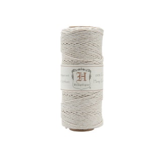 May include: A spool of natural-colored hemp twine with a label that reads "100%  Hemptique Hemp Cord 125 feet Hemptique.net".