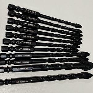 May include: A set of black drill bits with various sizes, including 3/16", 1/4", 5/16", and 1/2". Each bit has a hexagonal shank and a spiral flute design. The text "DKIBBITH" and the size are printed on each bit.
