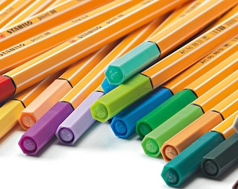 May include: A close-up of the tips of a set of colorful Stabilo highlighter pens. The tips are hexagonal and have a small leaf design on them. The colors include red, orange, yellow, green, blue, purple, and pink.