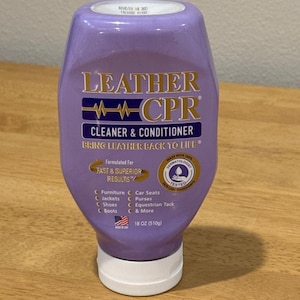 Puede incluir: Una botella morada de Leather CPR Cleaner & Conditioner. La etiqueta incluye el nombre del producto, una descripción y una lista de artículos en los que se puede usar, como muebles, chaquetas, zapatos y botas. La botella contiene 510g de producto.