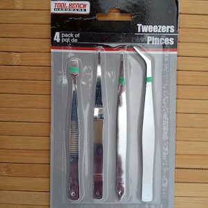 Peut inclure: Un paquet de quatre pinces argentées, étiquetées "Tweezers Pincers" et "Tool Bench Hardware". Le paquet indique "4 pack of pqt. de".