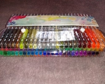 May include: A clear plastic package containing 48 colorful gel pens. The pens are arranged in rows and are all the same size. The package has a label that says "Buy Now - Happy Fun!" and "Art & Craft".