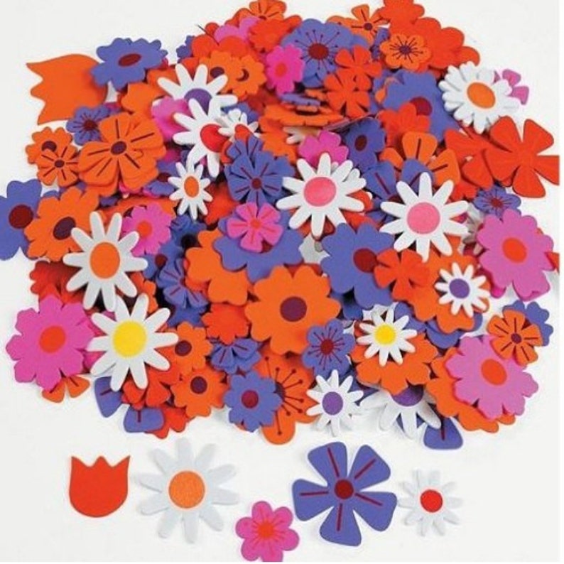 May include: A collection of colorful foam flower shapes in orange, pink, white, and purple. The flowers are in various sizes and styles, including daisies, tulips, and other floral designs.