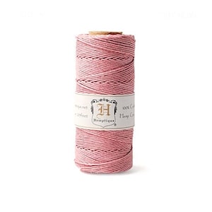 Puede incluir: Un carrete de cordón de cáñamo rosa, 100% natural, con una etiqueta que dice "Hemptique" y "100% Cordón de cáñamo de algodón".