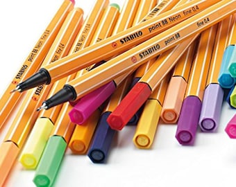 May include: A set of Stabilo point 88 neon fine tip markers with a variety of bright colors, including yellow, orange, pink, red, blue, green, and purple. The markers are arranged in a fan shape, with the tips facing the viewer. The markers are all labeled "Stabilo point 88 Neon fine 0.4".