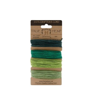 May include: A package of four spools of 100% hemp crafting cord in shades of green. The package is labeled "True Hemp" and "Hemptique" with the weight listed as 20lb. The cord is 4x9.1 meters or 4x29.8 feet.