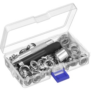 May include: A clear plastic storage box filled with silver metal eyelets and a tool for installing them. The box has a blue latch.