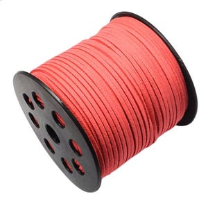 Puede incluir: Un carrete de cord&oacute;n de ante color coral. El cord&oacute;n est&aacute; enrollado alrededor de una bobina de pl&aacute;stico negro con m&uacute;ltiples aberturas circulares. El cord&oacute;n parece plano y tiene aproximadamente 3 mm de ancho, adecuado para varios proyectos de manualidades.