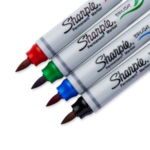 May include: Four Sharpie permanent markers with brush tips. The markers are red, green, blue, and black.